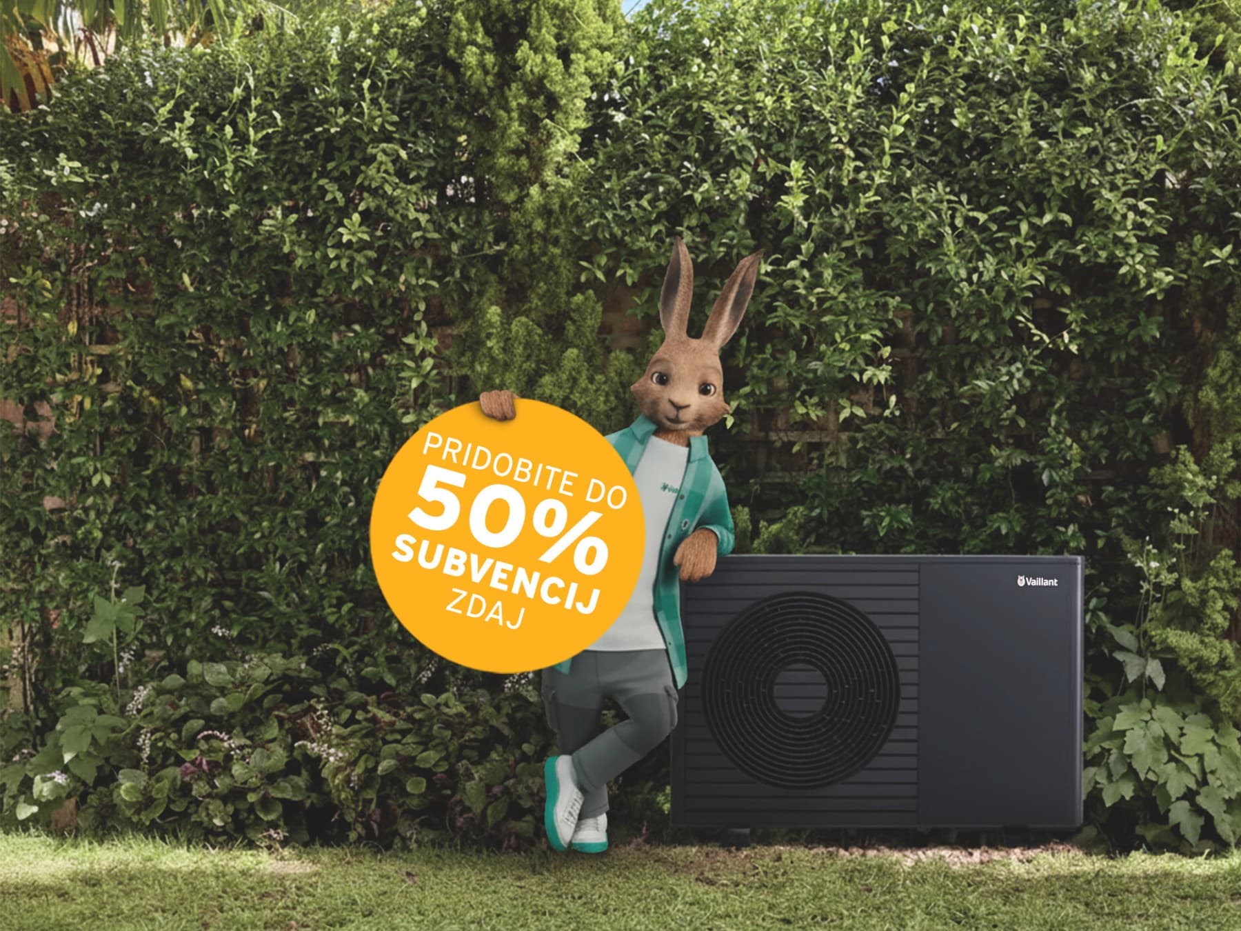 Vaillant zajec naslonjen na toplotno črpalko. V roki ima napis Pridobite do 50% subvencij zdaj