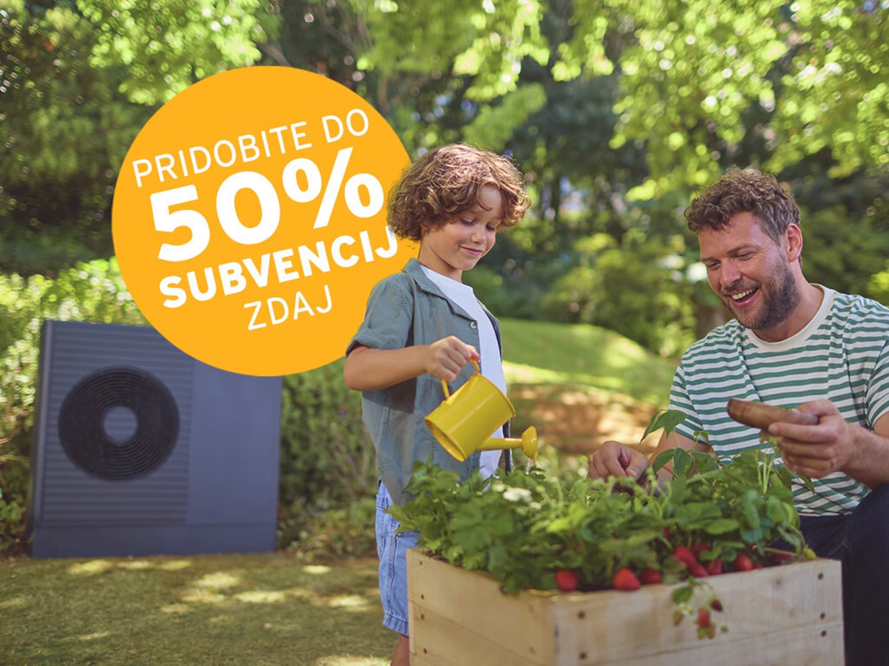Moški s sinom vrtnarita poleg znaka »Zdaj pridobite do 75 % subvencije«. Zunanja enota toplotne črpalke na vrtu.