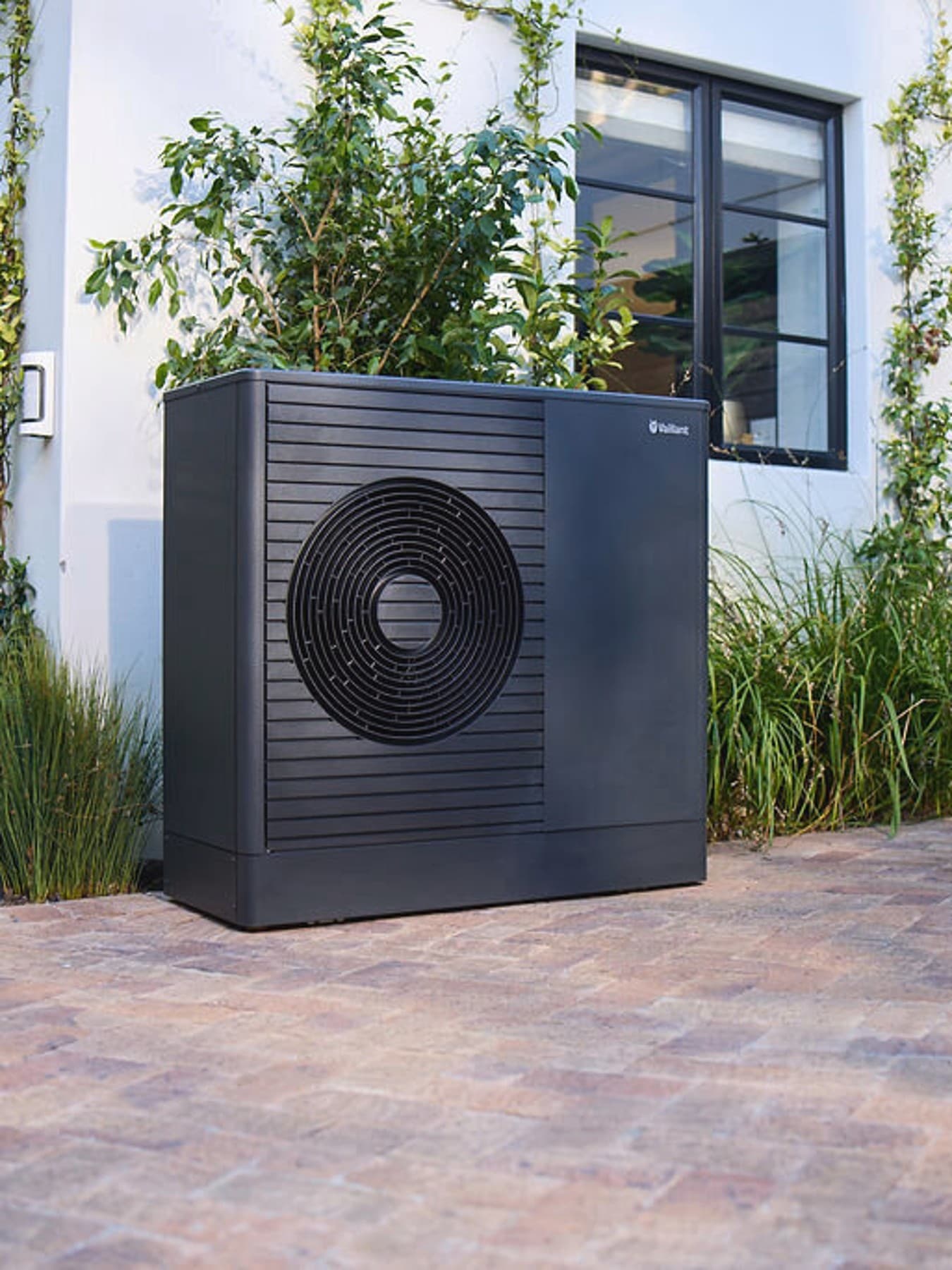 Toplotna črpalka Vaillant aroTHERM plus v prednjem vrtu hiše