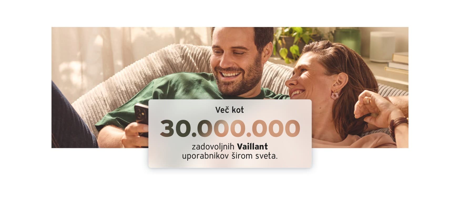 Srečen par sedi na kavču in prek telefona ureja nastavitve svojih ogrevalnih naprav Vaillant. Napis Več kot 30.000.000 zadovoljnih Vaillant uporabnikov širom sveta.